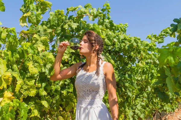 Giovane contadina assaggia un bicchiere di vino rosso . — Foto Stock