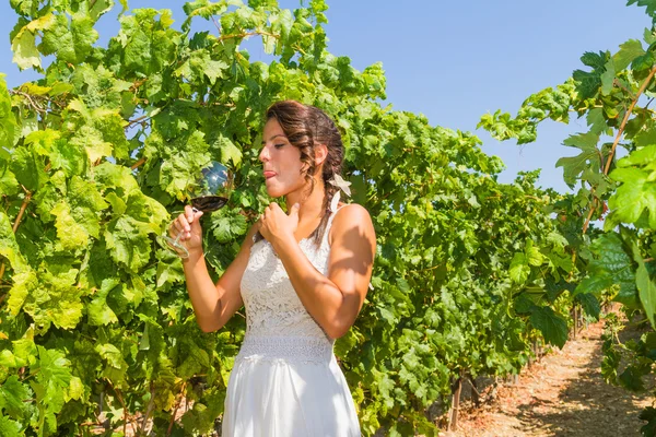 Jeune agricultrice goûte un verre de vin rouge . Images De Stock Libres De Droits