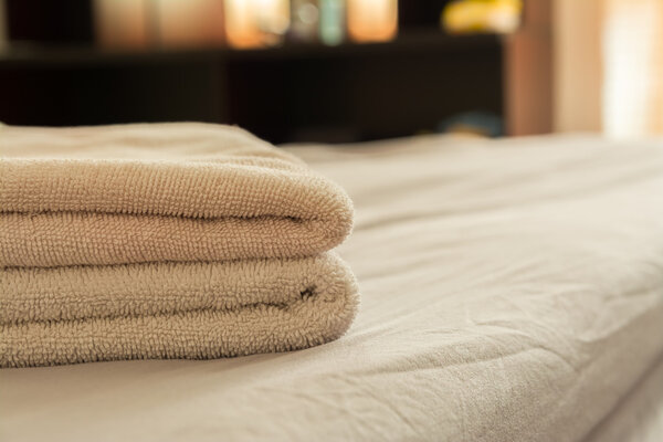 stack of towels on bed in bedroom