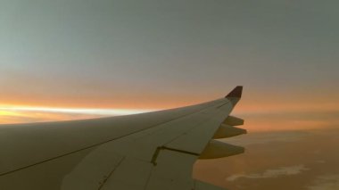Uçak kanadı ve gündoğumu pencere kenarı göster