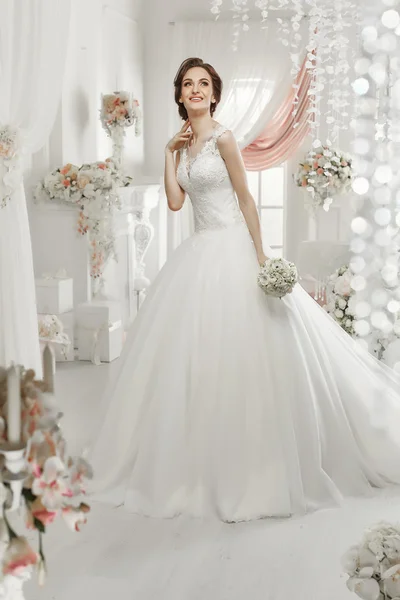 The beautiful woman posing in a wedding dress — Stock Photo, Image