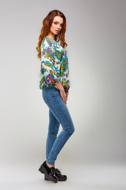 Bir graybackground üzerinde yürüme modern giyimleri şık, güzel kız. Güzellik, moda, stil.