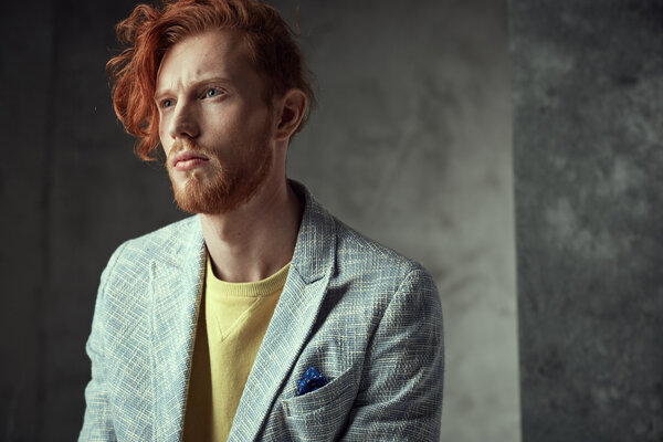 Portrait of a man with fiery curls on his head on the face of freckles.
