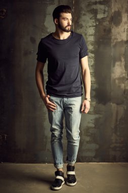 Yakışıklı delikanlı buket çiçek ile akıllı ceketli duvarın önünde poz veriyor.