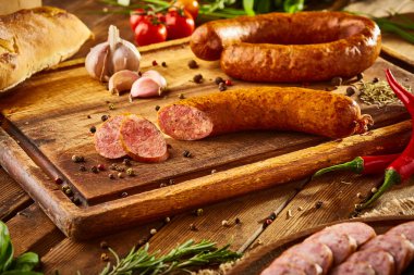 Natürmort - tahtaüzerinde yeşillik ile sosis ahşap bir arka plan üzerinde izole