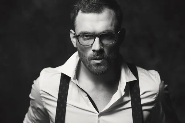 Beautiful man in shirt posing on a background of gray wall — Stock Photo, Image