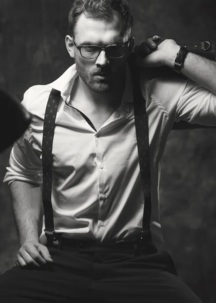 Vacker man i skjorta poserar på en bakgrund av grå vägg — Stockfoto