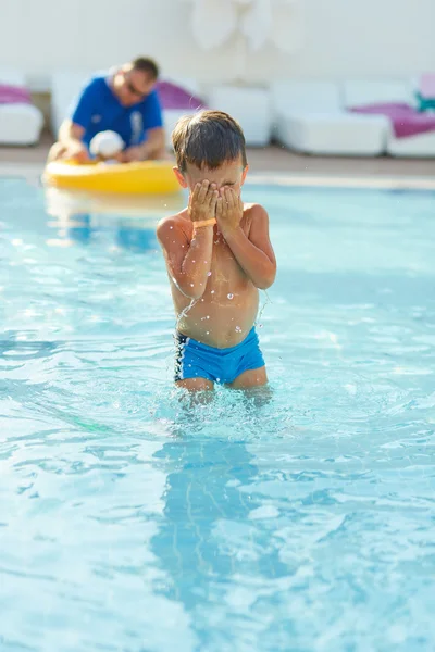 Bonito menino brincando na piscina ao ar livre — Fotografia de Stock