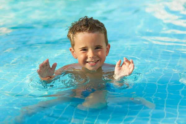 Bonito menino brincando na piscina ao ar livre — Fotografia de Stock