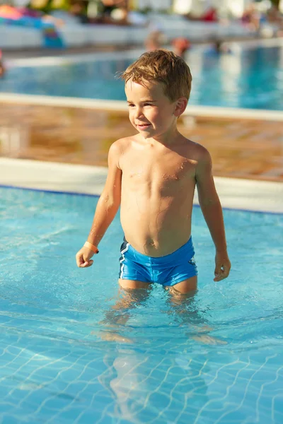 Bonito menino brincando na piscina ao ar livre — Fotografia de Stock