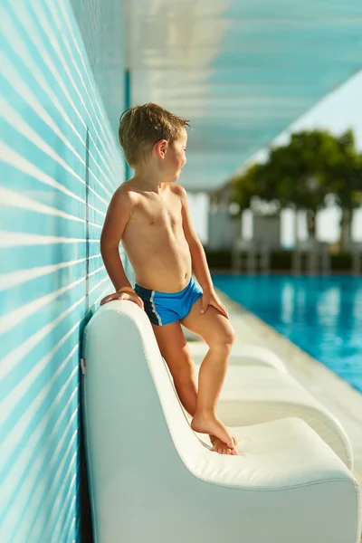 Bonito menino posando perto da piscina exterior — Fotografia de Stock