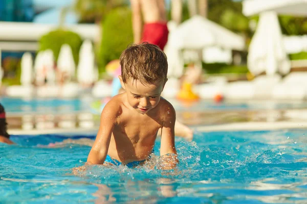 Bonito menino brincando na piscina ao ar livre — Fotografia de Stock