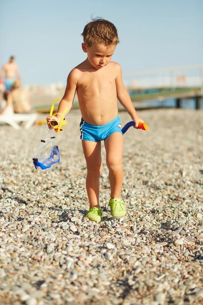 Bonito menino caminhando ao longo da praia do mar — Fotografia de Stock