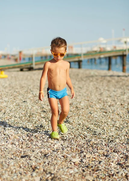 Bonito menino caminhando ao longo da praia do mar — Fotografia de Stock