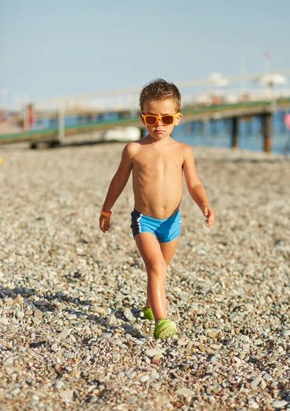 Bonito menino caminhando ao longo da praia do mar — Fotografia de Stock