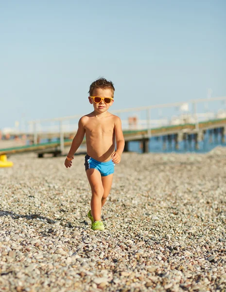 Bonito menino caminhando ao longo da praia do mar — Fotografia de Stock