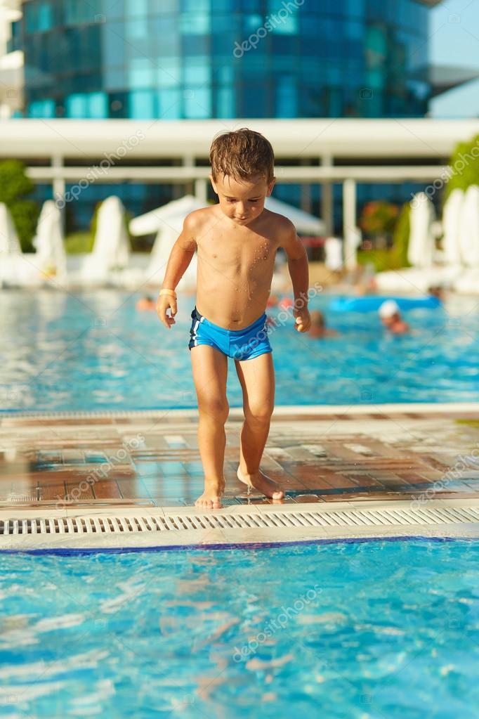 Cute little boy playing in outdoor swimming pool — Stock Photo