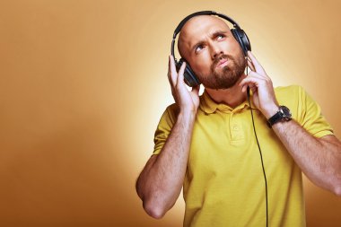 Genç adam ciddi bir yüz ile kulaklık giyen sakallı.