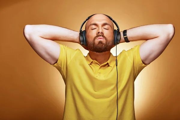 Jovem homem bonito ouvir a música com fones de ouvido e olhos fechados — Fotografia de Stock
