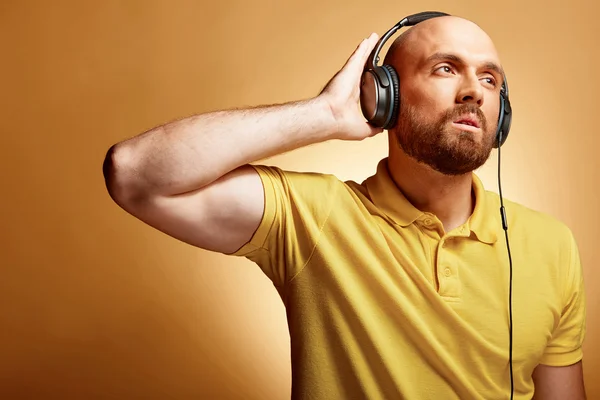 Jovem careca dj macho olhando para longe em amarelo t-shirt — Fotografia de Stock