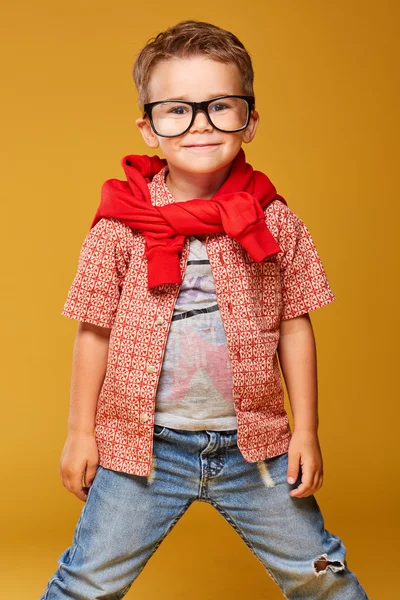 Niño bonito en gafas y jeans posando en el estudio — Foto de Stock