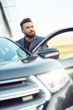 Yakışıklı genç model adam iyi arabanın yakınında poz