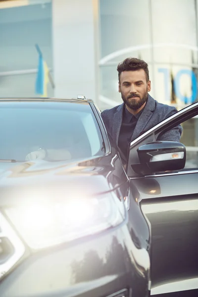 Красивый молодой человек с бородой позирует возле машины — стоковое фото