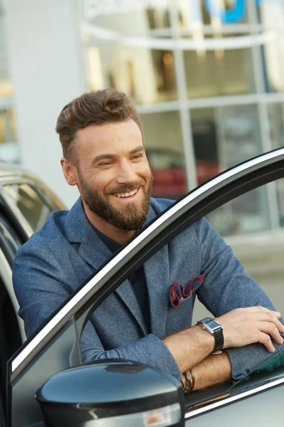 Красивый улыбающийся мужчина рядом с машиной — стоковое фото
