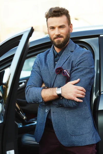 Bel homme barbu avec montre debout près de la voiture — Photo