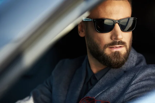 Handsome elegant serious man in a car — Stock Photo, Image