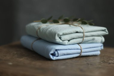 2 doğal ve ekolojik fotoğrafın yıkanmış pamuk kumaşları nane ve mavi renklerle geri sarılmış, üzerinde çuval iplik ve yeşil bitki var.