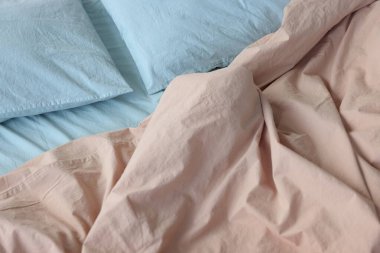 Yıkanmış pamuk yatak resmi: bej yorgan örtüsü ve mavi yastık kılıfı