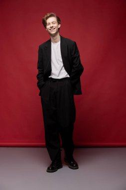 Sıradan takım elbiseli ve beyaz tişörtlü gülen adam.