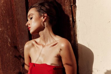 Genç, seksi bir İspanyol kızın portresi. Kıtır kıtır elmacık kemikleriyle. Kırmızı elbiseli.