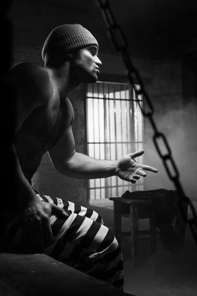 The prisoner worries about a criminal conduct being behind a lattice — Stock Photo, Image