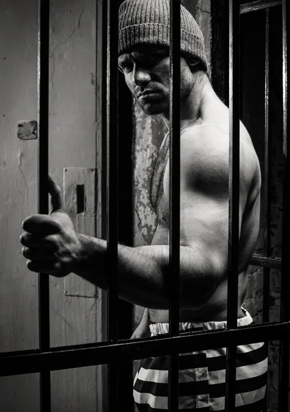 The prisoner worries about a criminal conduct being behind a lattice — Stock Photo, Image