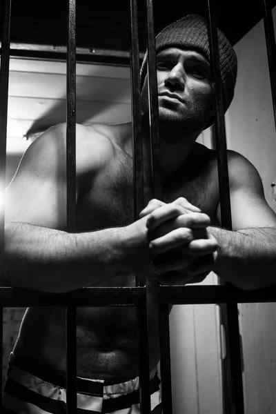 O prisioneiro se preocupa com uma conduta criminosa por trás de uma rede — Fotografia de Stock