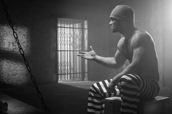 O prisioneiro se preocupa com uma conduta criminosa por trás de uma rede — Fotografia de Stock