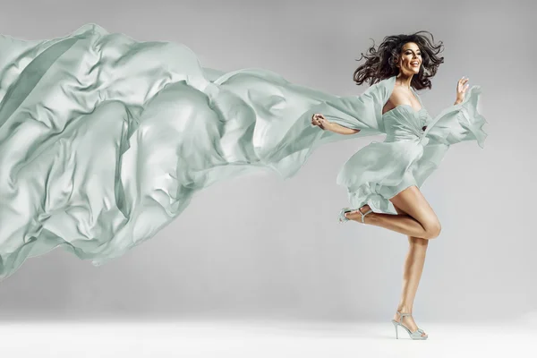 Frau im wehenden Kleid mit fliegendem Stoff — Stockfoto