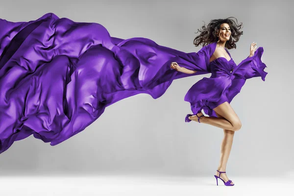 Woman in waving dress with flying fabric Stock Picture