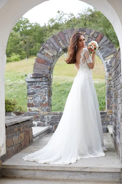 La bella giovane donna posa in un abito da sposa — Foto Stock