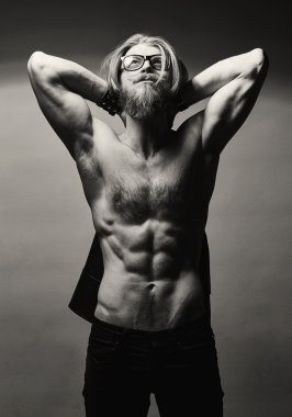 Çıplak göğüslü gri duvardan poz ile acımasız sakallı adam.