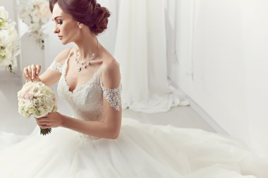 The beautiful woman posing in a wedding dress