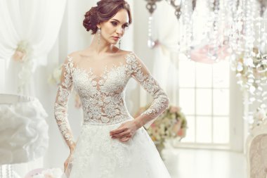 The beautiful woman posing in a wedding dress