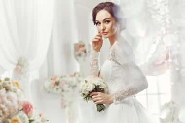 The beautiful woman posing in a wedding dress