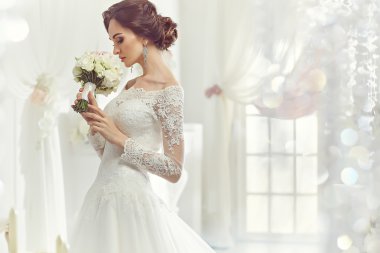 The beautiful woman posing in a wedding dress