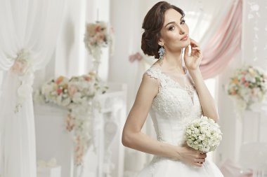 The beautiful woman posing in a wedding dress