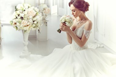 The beautiful woman posing in a wedding dress