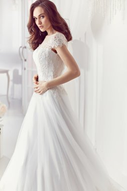 The beautiful woman posing in a wedding dress