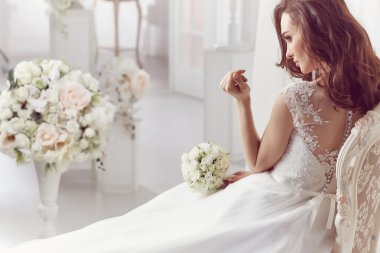The beautiful woman posing in a wedding dress